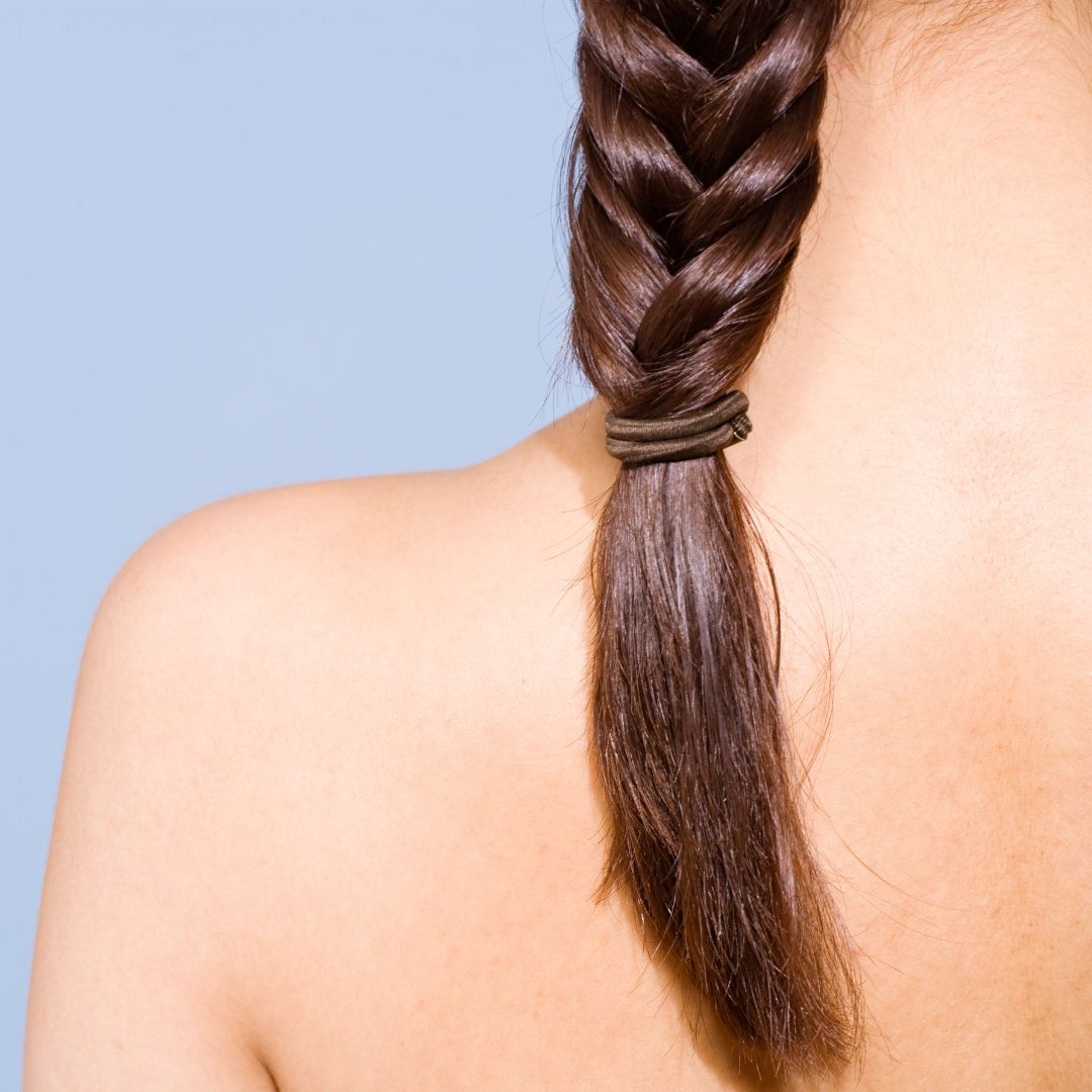 A woman with a braided hairstyle, featuring long brown hair, highlighting Loxxie Hair brand.