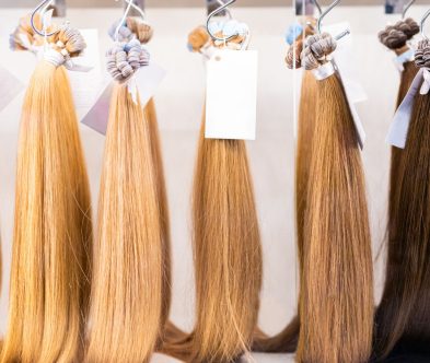 A row of colorful hair extensions displayed in a Loxxie Hair salon, showcasing various styles and lengths.